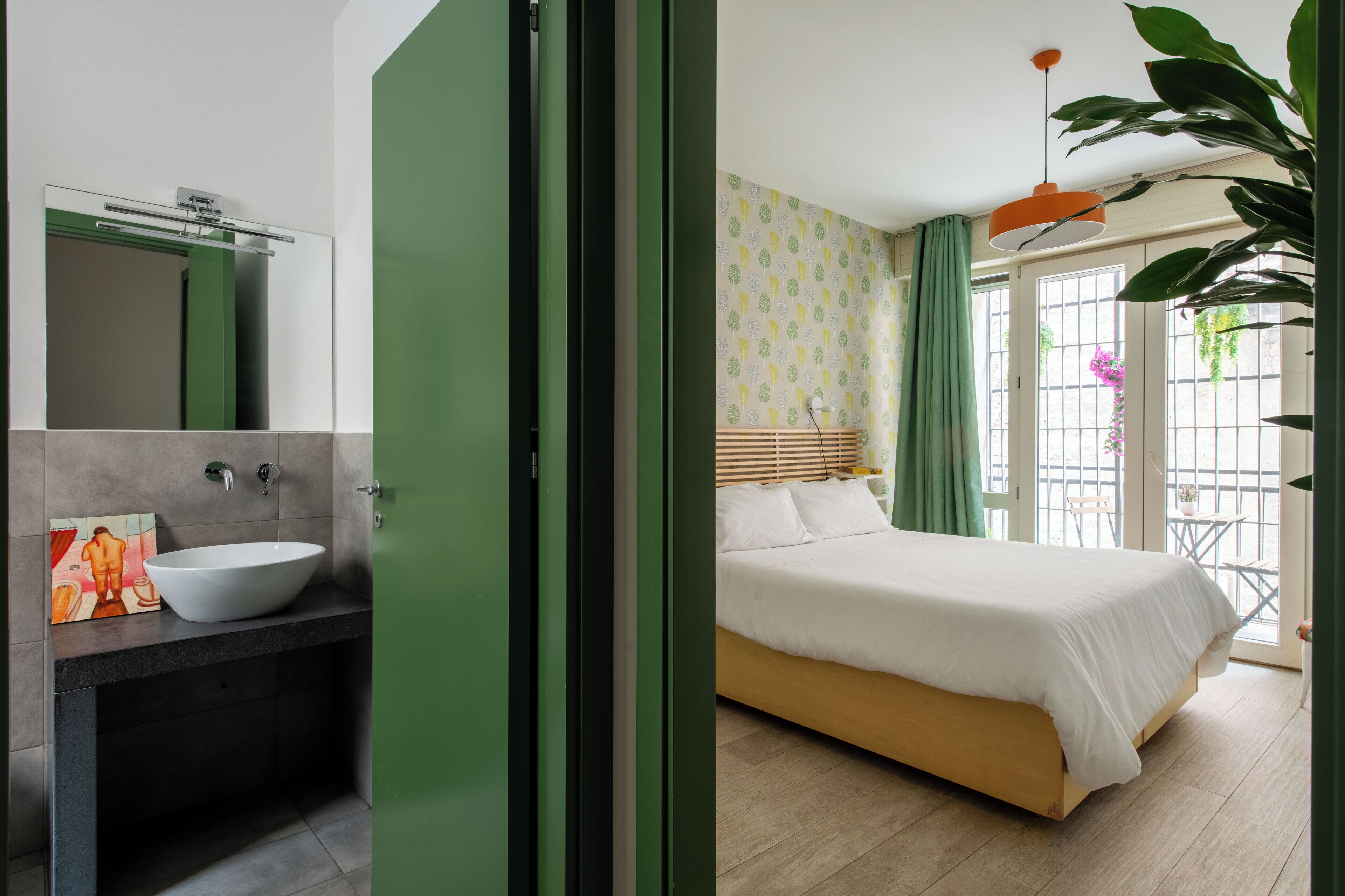 A modern bathroom with a white sink and a green door.