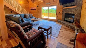 Un intérieur de chalet chaleureux avec une cheminée, des meubles en bois et un mur en pierre.