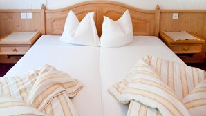 A double bed with a wooden headboard, two bedside tables, and striped bedspreads. - Garni Appartement Collina (Samnaun)