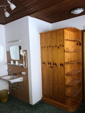 A bathroom with a wooden wardrobe, a sink, and a mirror. - Garni Appartement Collina (Samnaun)