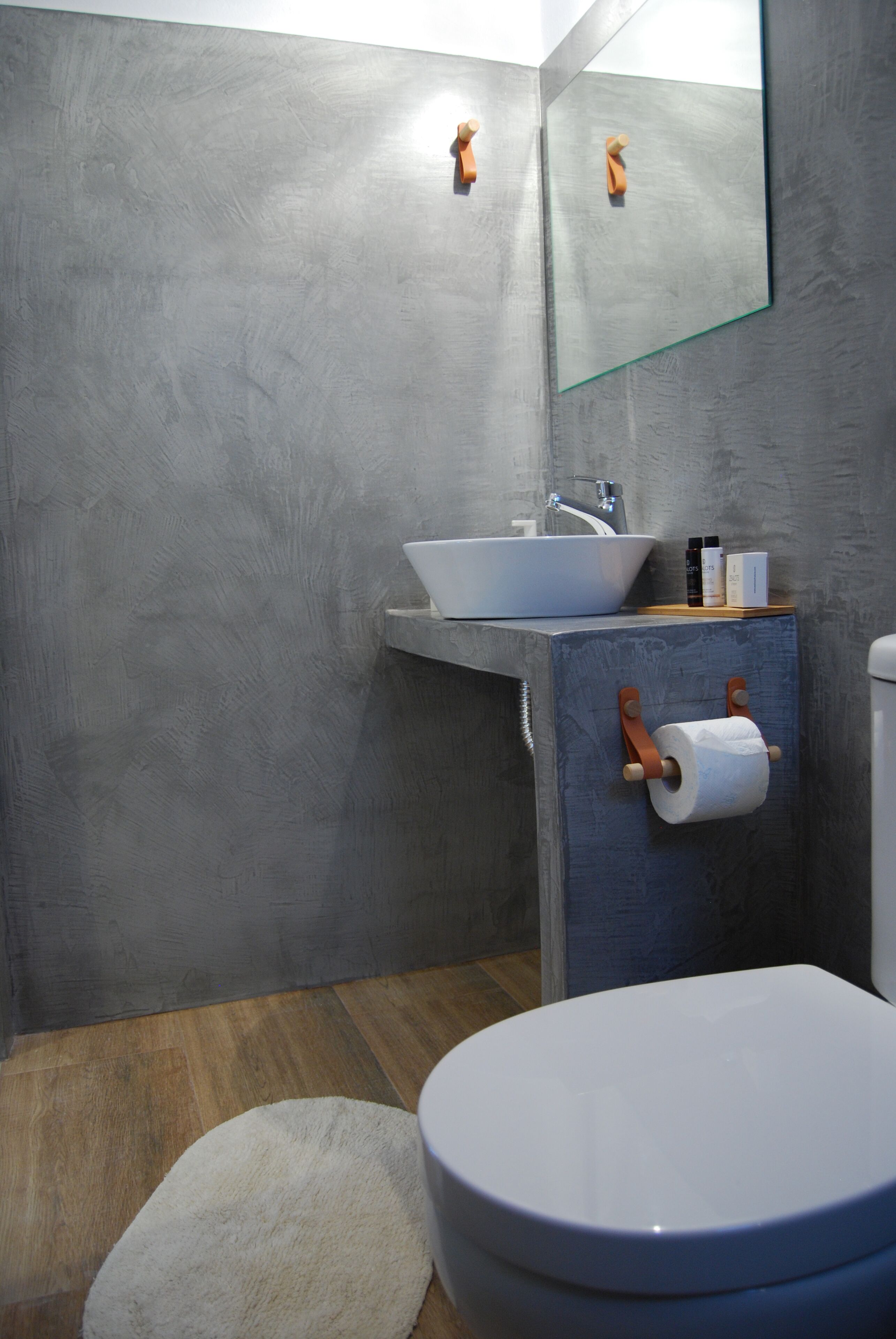A bathroom with a white sink, a toilet, and a mirror.