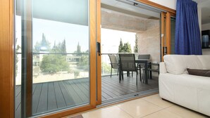 A modern living room with a sliding glass door leading to an outdoor patio area.