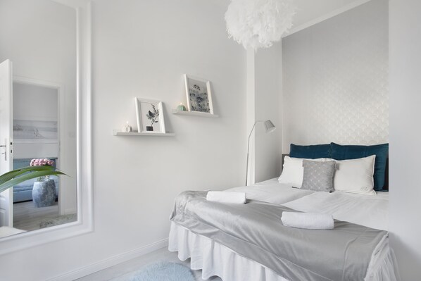 Un dormitorio moderno con una cama grande, una lámpara de noche y vistas a un baño.
