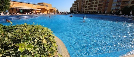 Een seizoensgebonden buitenzwembad, parasols voor strand/zwembad