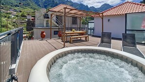 A rooftop terrace with a hot tub, wooden pergola, and a dining area overlooking a mountainous landscape. - Villa Teresa/1 by Atlantic Holiday (São Vicente)