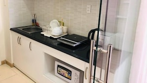 Een moderne keuken met witte kastjes, een zwart aanrecht, een afwasschaal en een ingebouwde weegschaal.