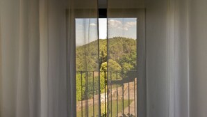 A window with a view of a forested hillside. - Santuari de Terrades (Terrades)