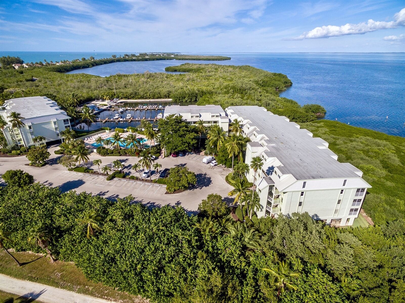 Un resort con puerto deportivo, piscina y vistas al océano.