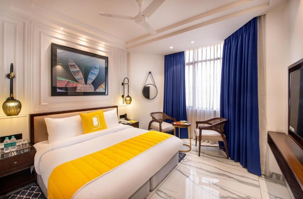A hotel room with a bed, a television, a desk, and a chair.