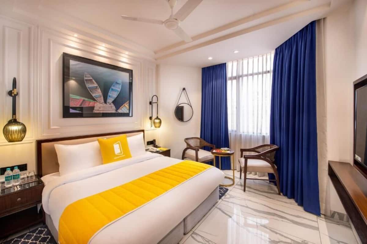 A hotel room with a bed, a television, a desk, and a chair.