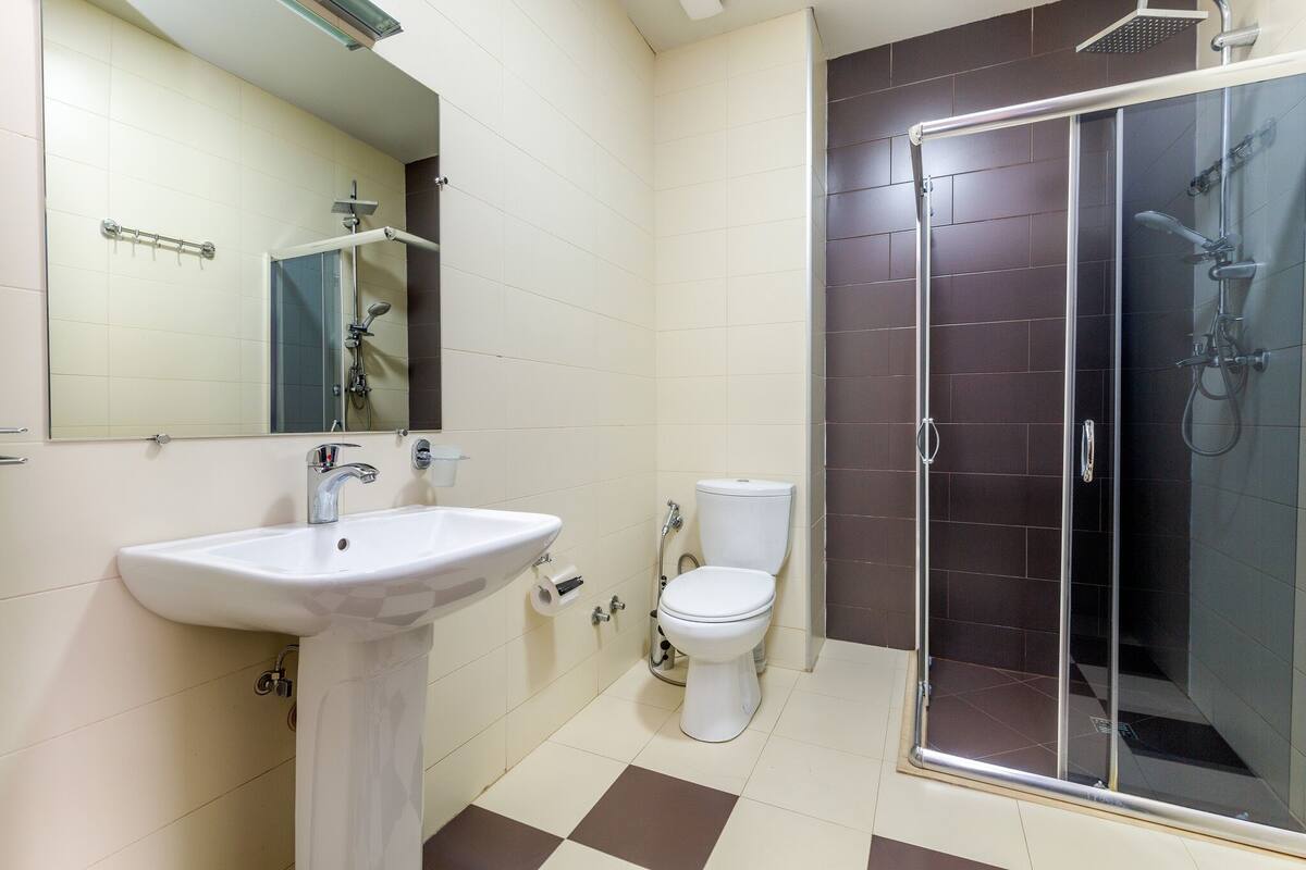 A bathroom with a white sink, a toilet, and a glass-enclosed shower.