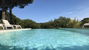 A clear swimming pool with lounge chairs and a view of dense trees in the background. - Villa Apartment T4 with 4 terraces Porto Vecch swimming pool garden quiet (Porto-Vecchio)