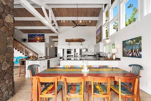 A spacious kitchen with a central island, white cabinetry, and a ceiling fan.