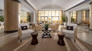 A spacious lobby with high ceilings, large windows, and a central coffee table surrounded by sofas and armchairs. - Gateway Grand 1206 Sleeps 12 and includes linens, George Foreman Grill and Game Table!! (Ocean City)