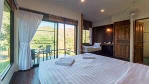 A bedroom with a large bed, a window with curtains, a fan, and a view of the outdoors. - Chiang Mai Elephant Friends (Mae Wang)