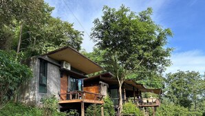 A modern eco-friendly house with multiple levels, surrounded by lush greenery and trees. - Chiang Mai Elephant Friends (Mae Wang)