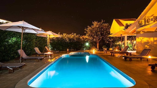 Piscine extérieure en saison, parasols, chaises longues