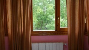 Ein Zimmer mit Fenster, Vorhängen und Heizkörper.