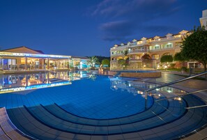 A swimming pool with a tiled deck, a restaurant named "Rockstar" in the background, and a multi-story building with balconies. - Ionion Blue Hotel (Zakynthos)