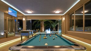A pool table with balls, a television screen, and a palm tree outside. - Ionion Blue Hotel (Zakynthos)