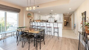 A modern kitchen with white cabinets, a central island, and pendant lighting. - Upscale, stylish 3 bedroom condo with free WiFi, and outdoor pool, and a breathtaking view of the bay located in midtown and only two blocks from the beach! (Ocean City)