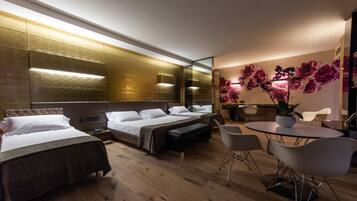 Une chambre d’hôtel moderne avec deux lits, un coin salon comprenant une table et des chaises, et un mur décoratif orné de fleurs.