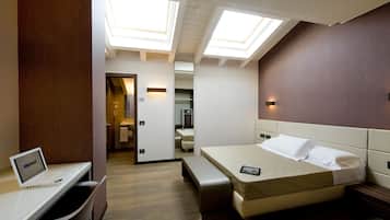 Une chambre d’hôtel moderne équipée d’un lit, d’un bureau avec un ordinateur portable et de fenêtres de toit.