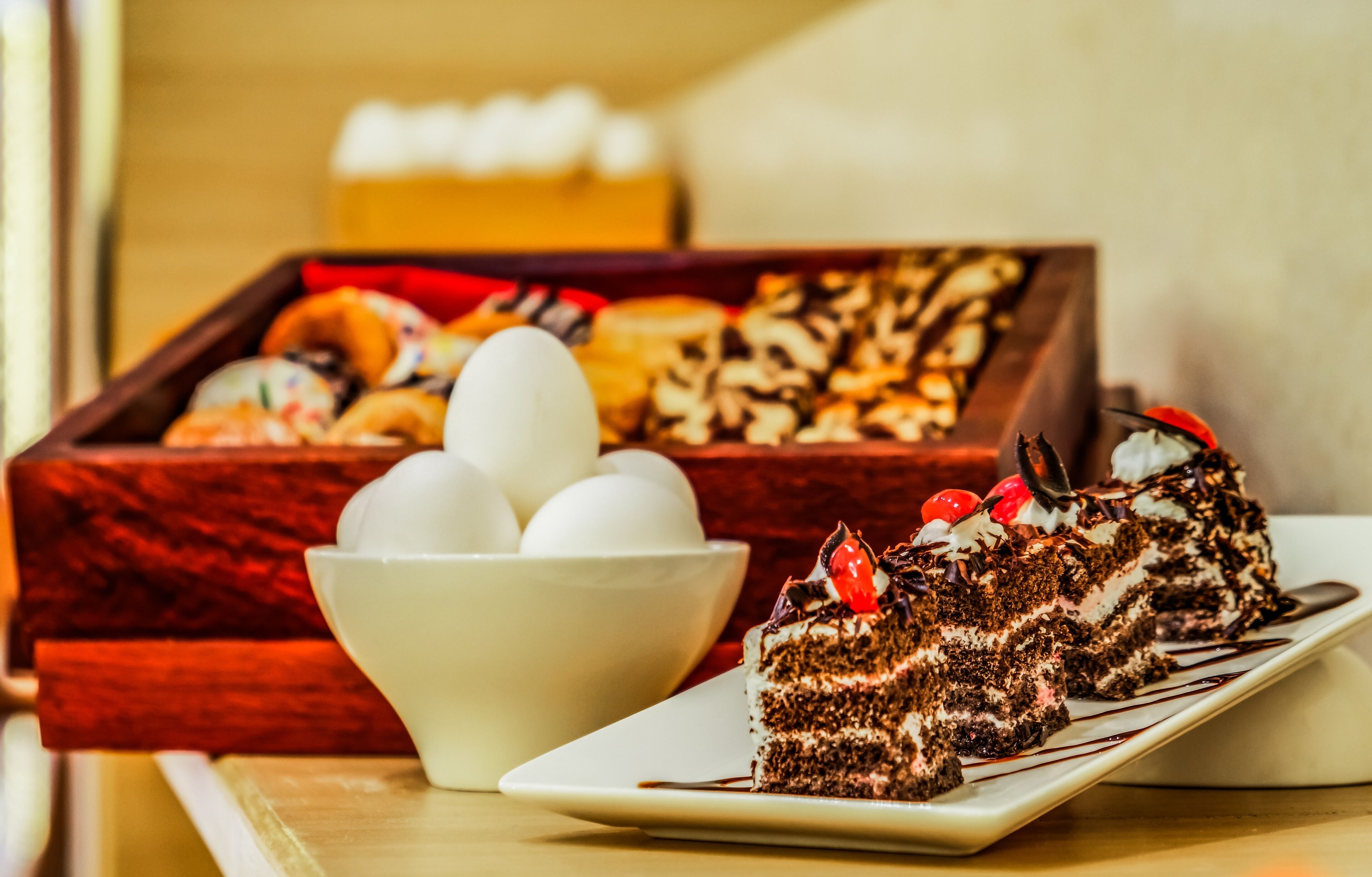 Una bandeja de postres con diferentes pasteles y una porción de pastel de chocolate en un plato.