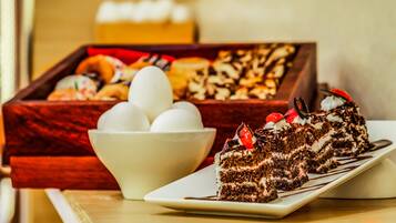 Una bandeja de postres con diferentes pasteles y una porción de pastel de chocolate en un plato.