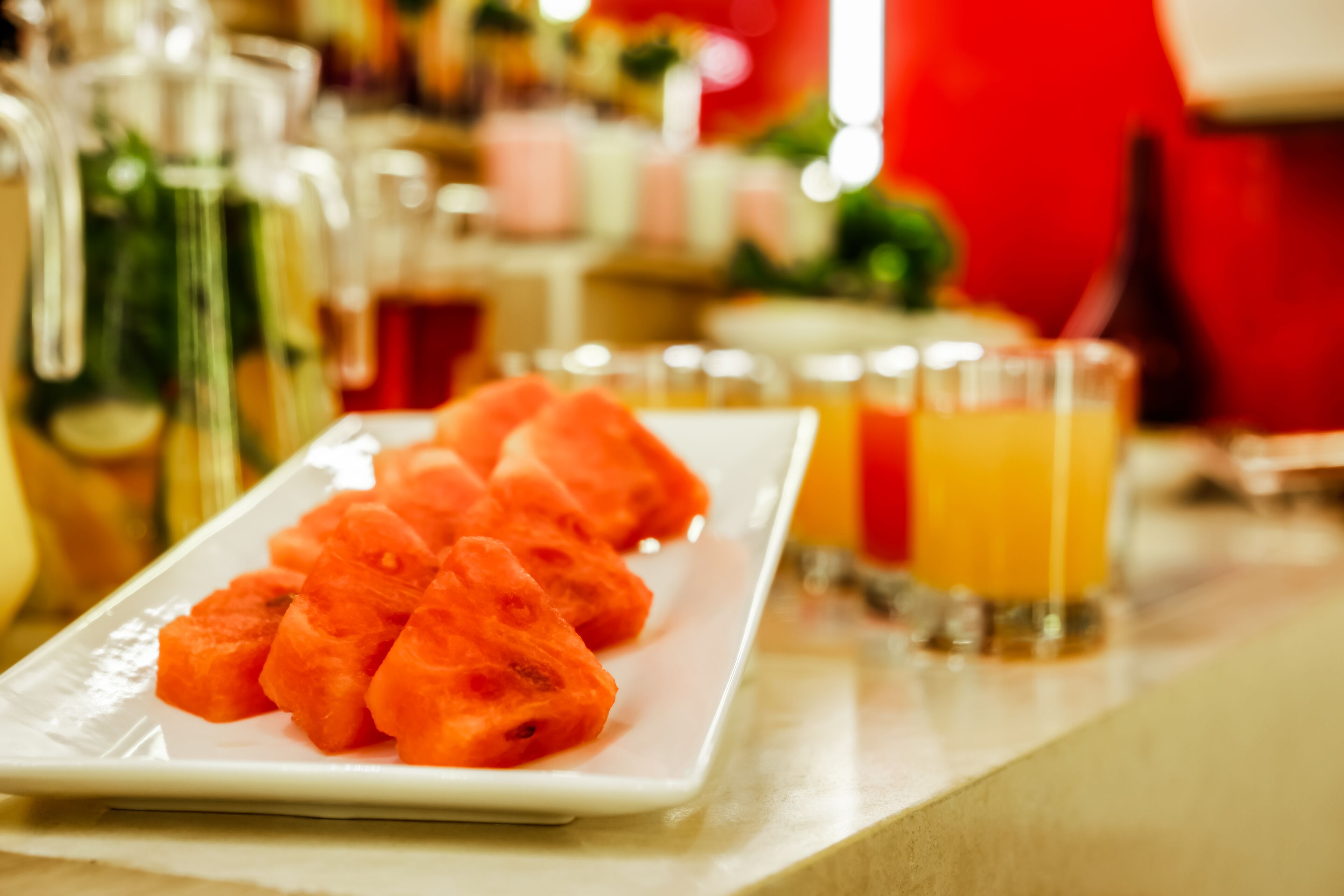 A white rectangular plate with cubed watermelon slices on a table.