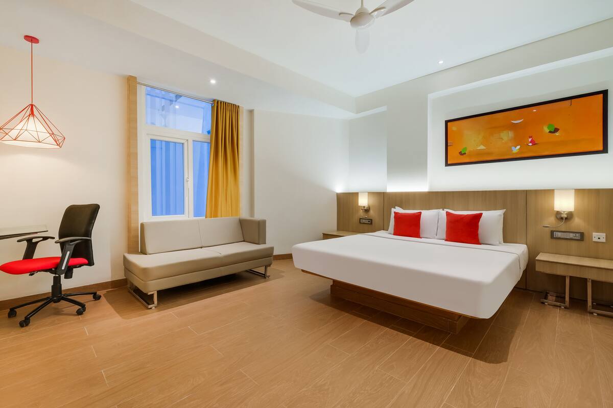 Une chambre d’hôtel moderne avec un grand lit, un canapé, un bureau et une chaise.