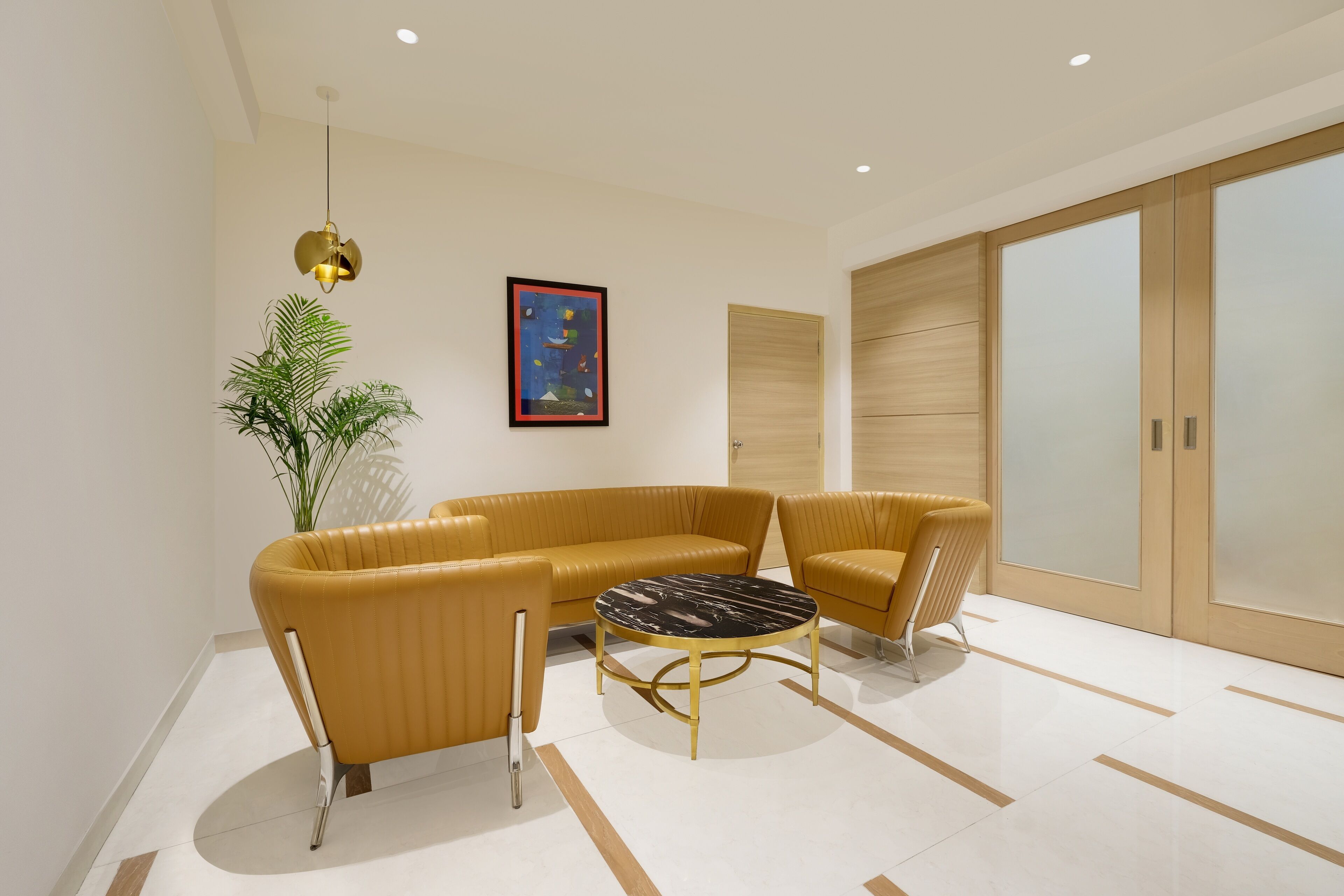 A modern living room with a sectional sofa, a round coffee table, and a potted plant.