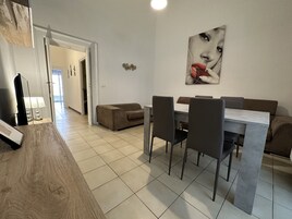Apartamento Deluxe | Zona de estar | Televisión de pantalla plana de 50 pulgadas con canales digitales