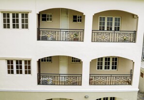 A multi-story building with balconies, each with wrought iron railings and potted plants. - Apartment Royale Hotel and Suite (Lagos)