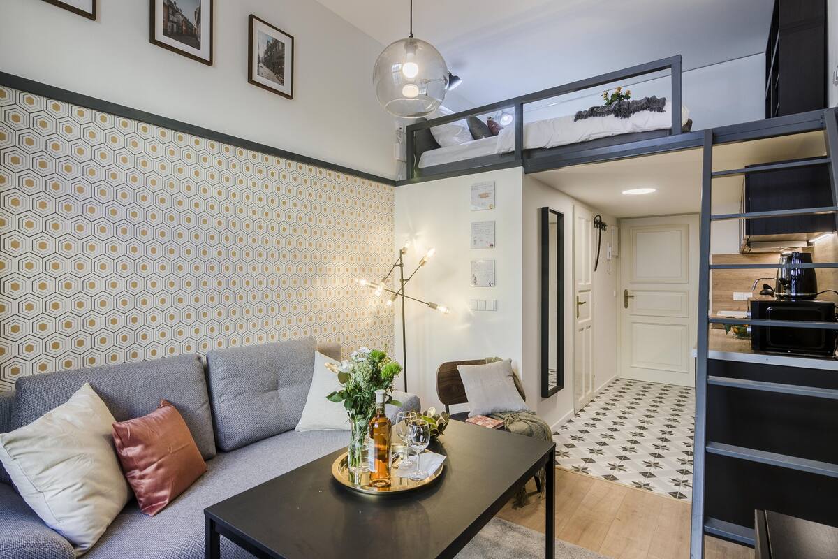 Ein modernes Wohnzimmer mit einer Couch, einem Couchtisch mit Tablett und einem Etagenbett.