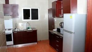 Una cucina attrezzata con piano cottura, lavello, forno a microonde e frigorifero.