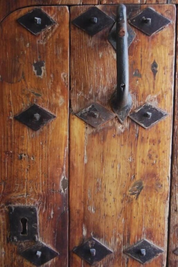 A wooden door with metal hinges and a keyhole. - Palacio Sirvente de Mieres (Andujar)