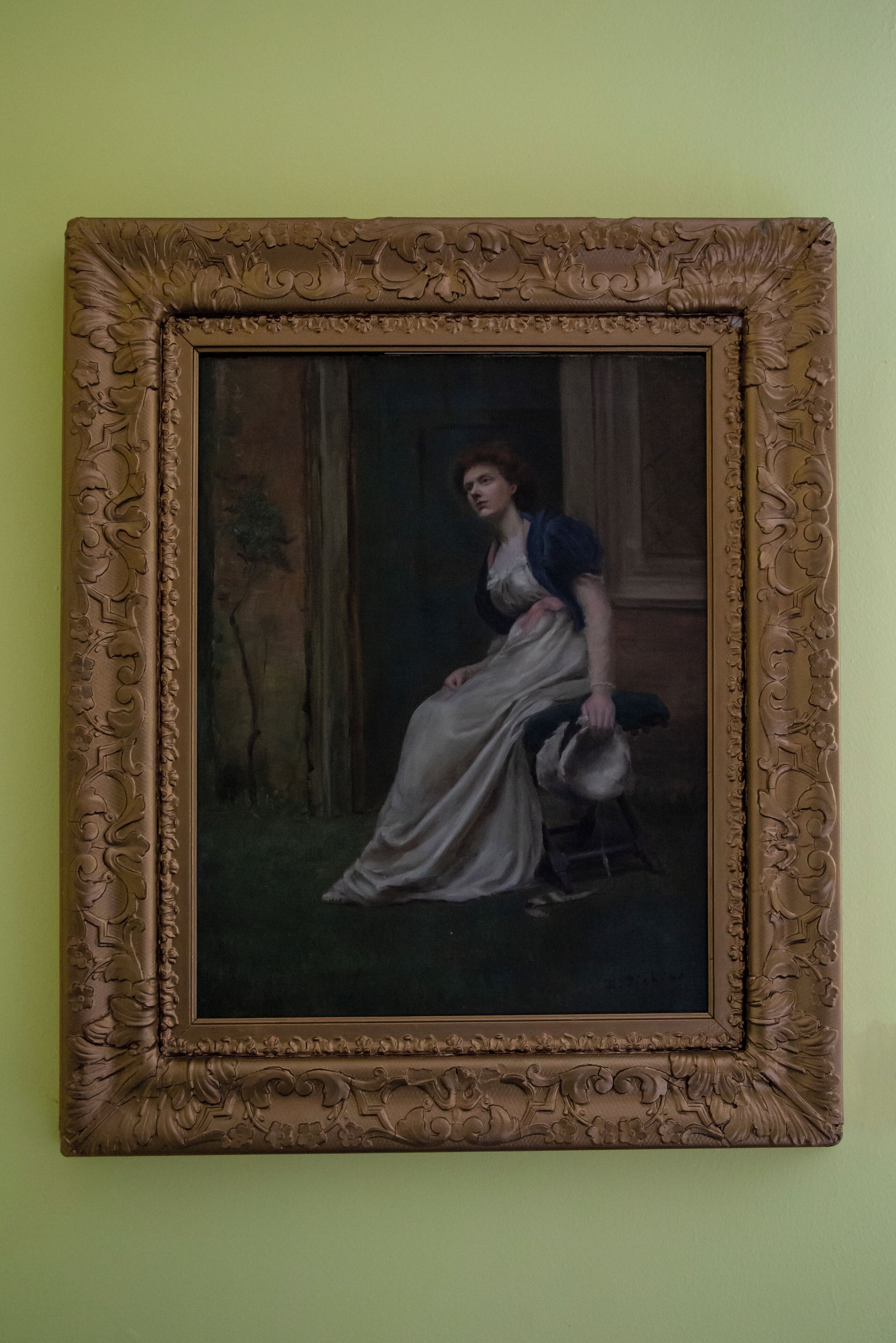 Ein Gemälde mit aufwendiger, detailreicher Rahmung, an einer Wand angebracht.