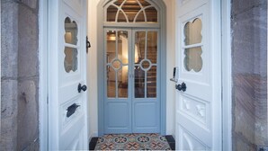 A white door with a glass panel and a decorative arch above it. - Posada Seis Leguas (Cartes)