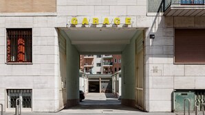 Entrada de un edificio con la leyenda 'GARAGE' y un camino despejado que conduce al interior.