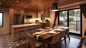 Une cuisine moderne avec des meubles en bois, un réfrigérateur en acier inoxydable et un coin bar.