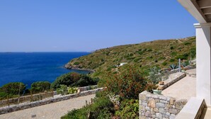 A coastal view with a stone pathway leading to a building with a white facade.