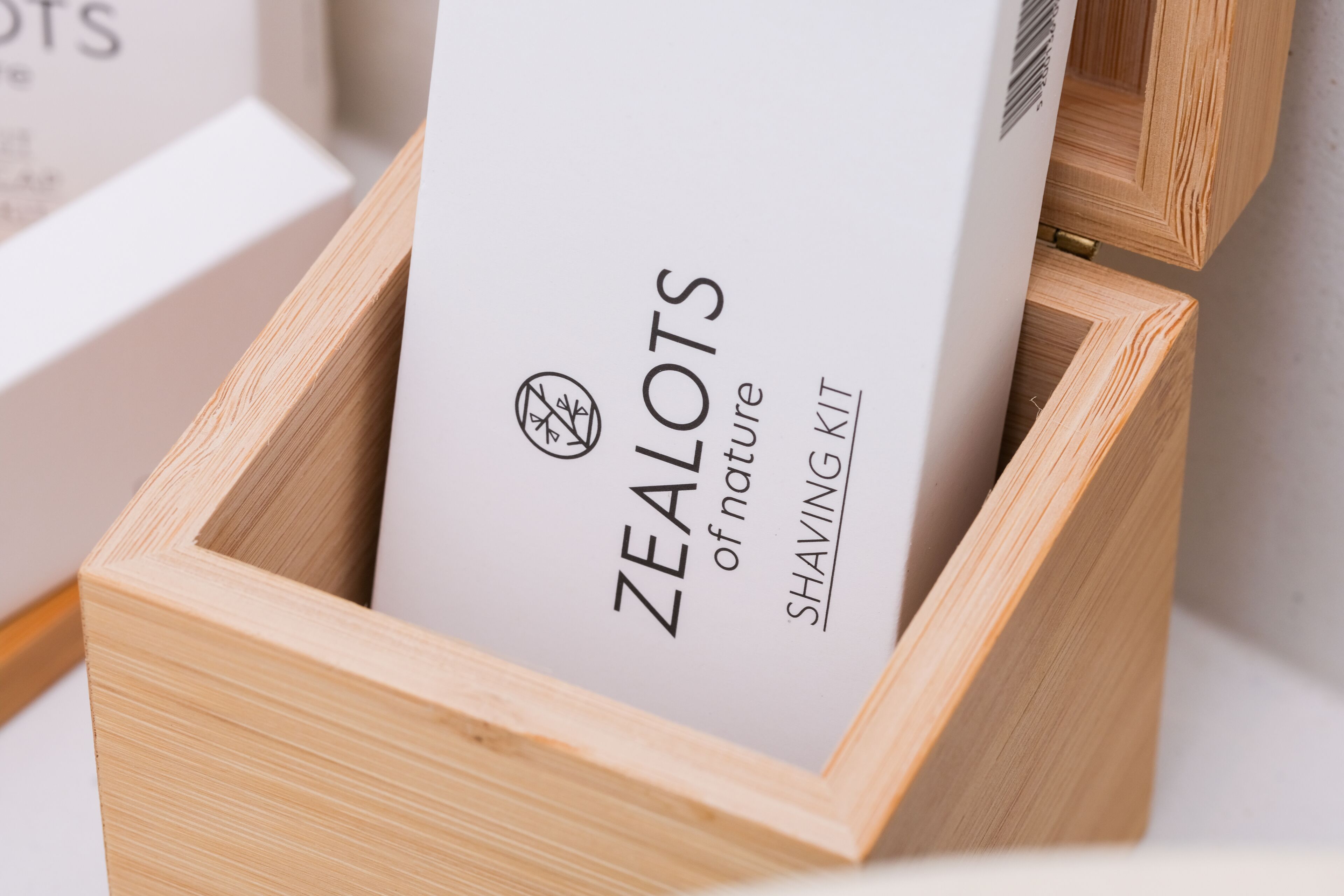 A wooden box containing a product labeled "ZEALOTS of nature SHAVING KIT".