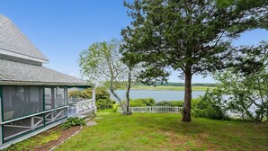 Une maison dotée d’un porche abrité donnant sur un lac.