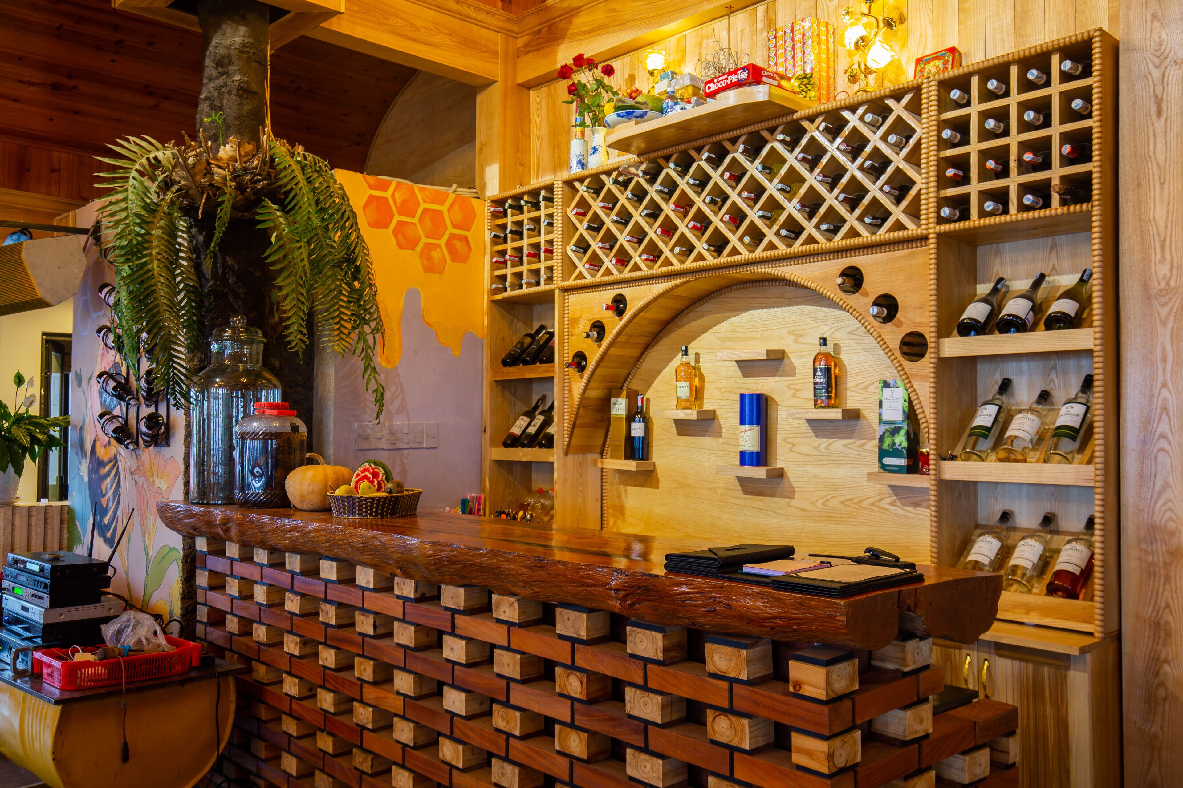 Eine Bar mit Holzboden, Weinregalen und einer Zimmerpflanze.