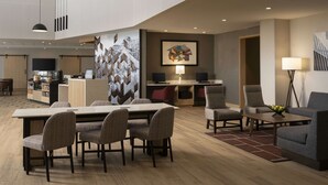A modern hotel lobby with a dining area, a reception desk, and a seating area with a coffee table. - Hyatt Place Amarillo-West (Amarillo)