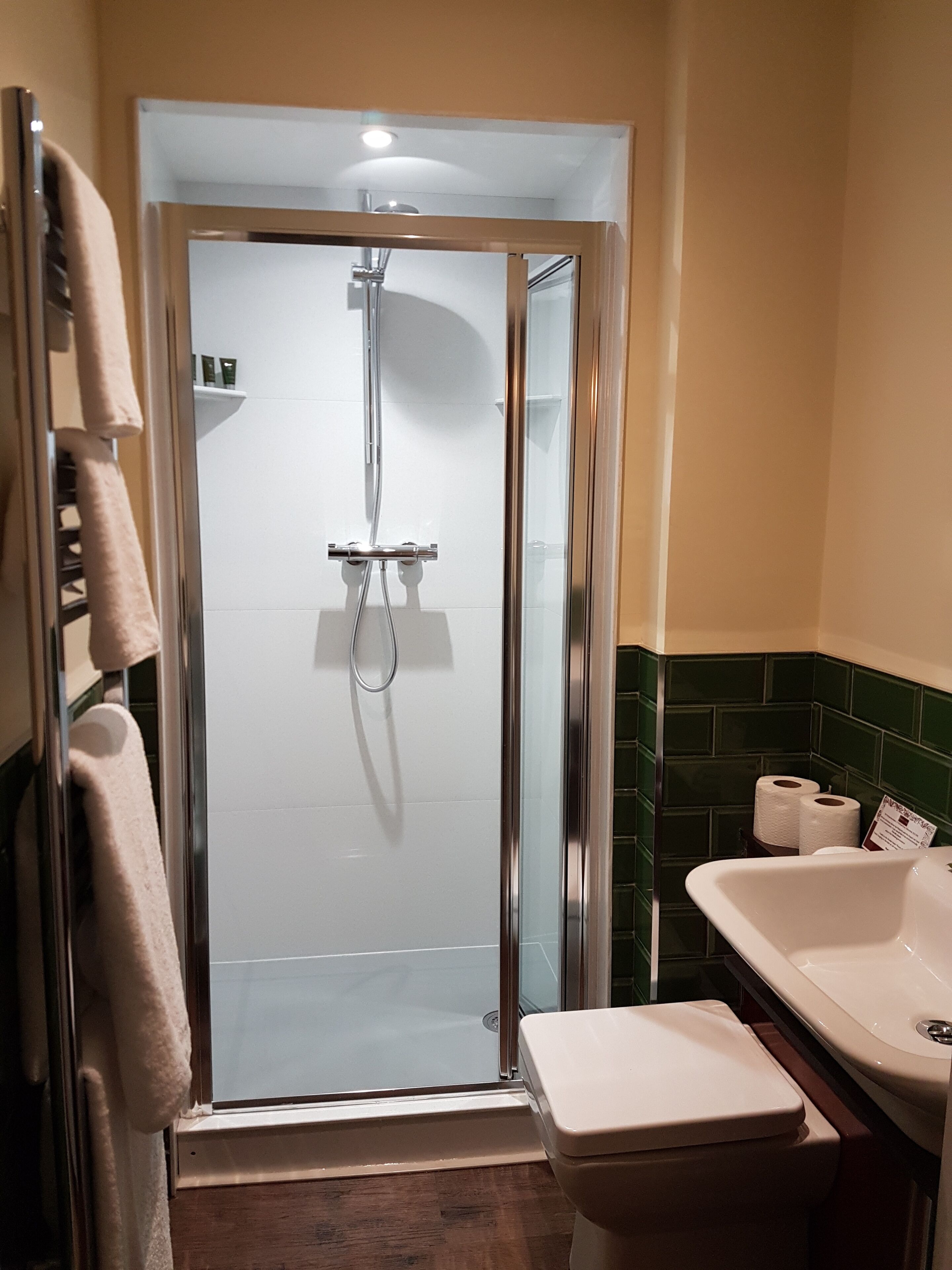 Un baño con ducha de vidrio, inodoro blanco y bañera.