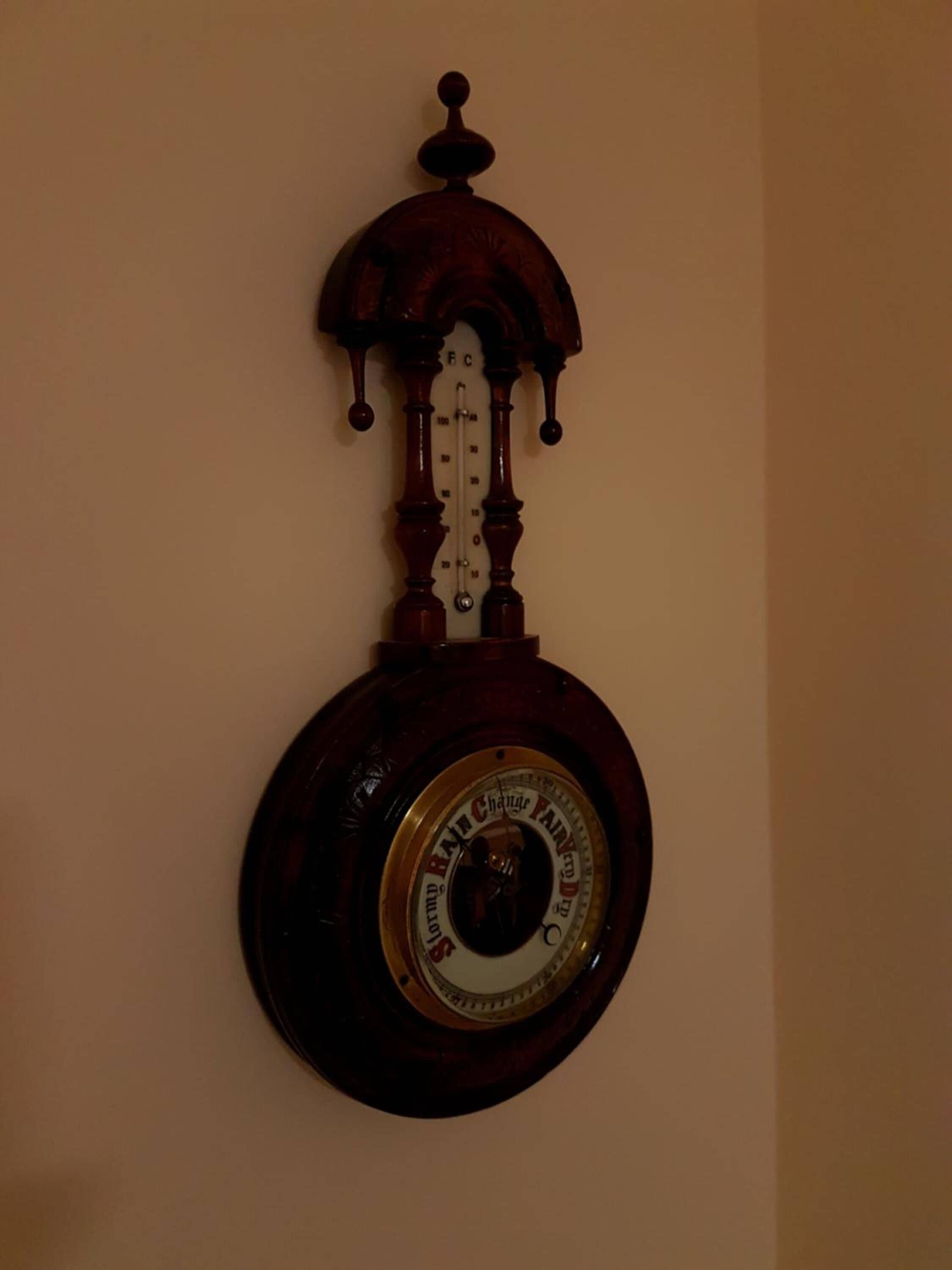 Un reloj de pared analógico con esfera redonda y péndulo.