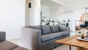 Un salón moderno con un sofá gris, una mesa de centro de madera y un sillón colgante.