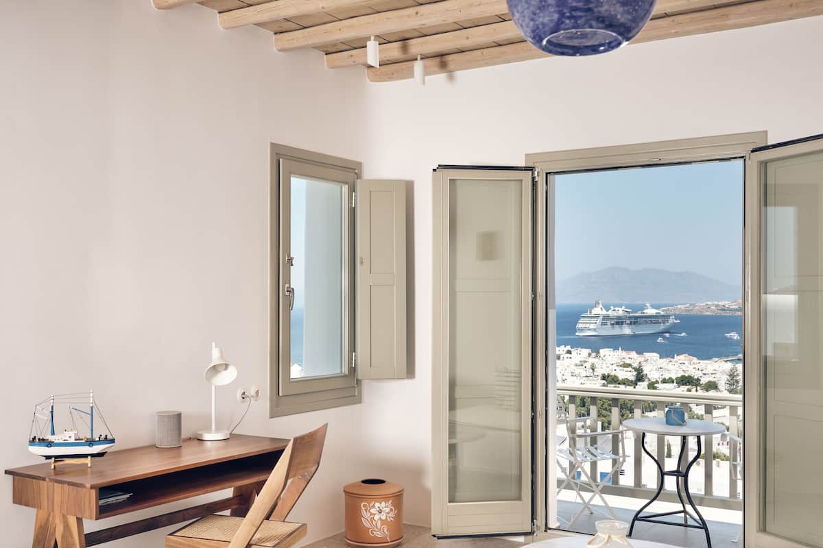 Un balcon avec vue sur un navire de croisière et une ville côtière.